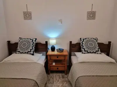 a bedroom with two beds and a table with a lamp at ANiko in Kolimbia