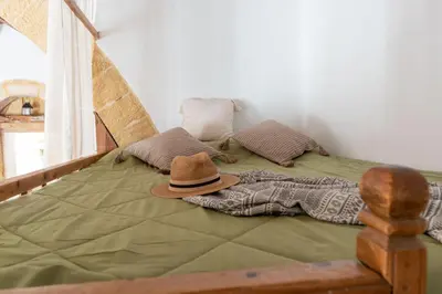 a bed with a hat sitting on top of it at La Casa di Varvara e Nikolas in Soroni