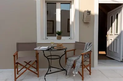 a table with two chairs and a glass of wine at La Casa di Varvara e Nikolas in Soroni