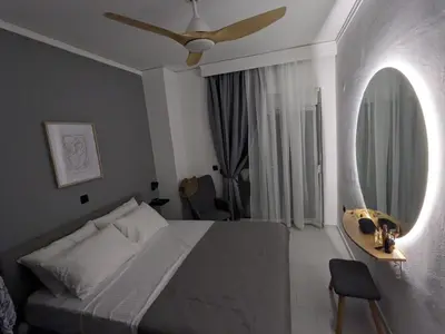 a bedroom with a bed and a mirror and a table at Mini Mansion in Rhodes Town