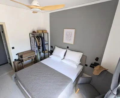 a bedroom with a bed and a ceiling fan at Mini Mansion in Rhodes Town