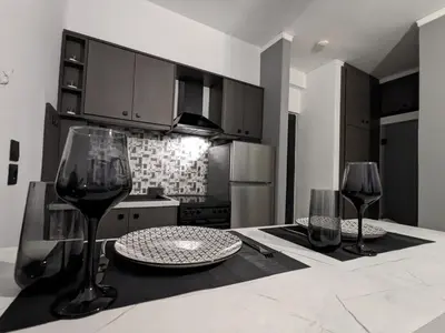 a kitchen with a table with two glasses of wine at Mini Mansion in Rhodes Town