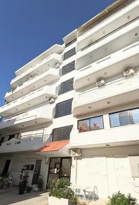 a white building with a table outside of it at Mini Mansion in Rhodes Town