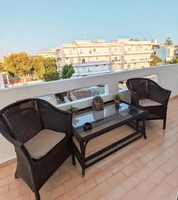 a balcony with two chairs and a coffee table at Mini Mansion in Rhodes Town
