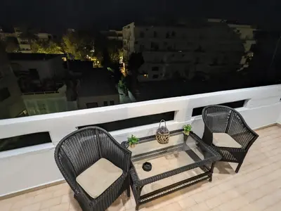 two chairs and a coffee table on a balcony at Mini Mansion in Rhodes Town