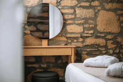 a bedroom with a mirror on a stone wall at Manolis Seaside Villa in Soroni