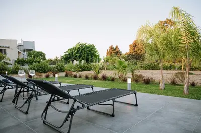 a group of chairs and tables on a patio at Manolis Seaside Villa in Soroni