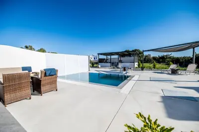a patio with a swimming pool and a house at Vigla Kiotari in Kiotari