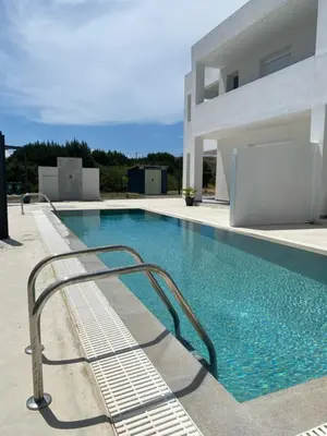 a swimming pool with a metal handrail next to a building at Vigla Kiotari in Kiotari