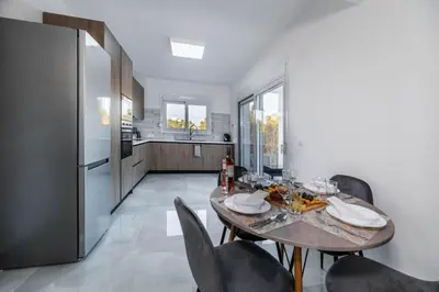 a kitchen with a table and chairs and a refrigerator at Vigla Kiotari in Kiotari