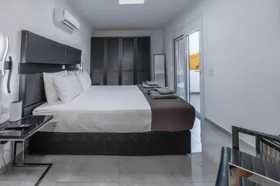 a bedroom with a large bed and a balcony at Vigla Kiotari in Kiotari
