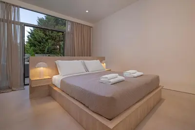 a bedroom with a large bed and a large window at Natural Harmony ,Luxury Studio Oasis & Hot Tub in Rhodes Town