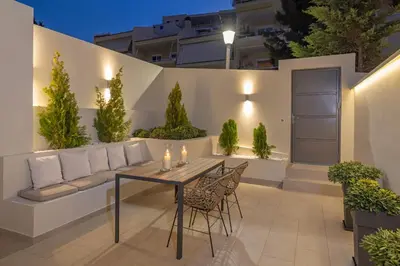a patio with a table and chairs and a couch at Natural Harmony ,Luxury Studio Oasis & Hot Tub in Rhodes Town
