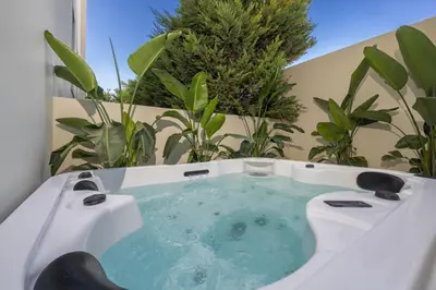 a jacuzzi tub in a balcony with plants at Natural Harmony ,Luxury Studio Oasis & Hot Tub in Rhodes Town