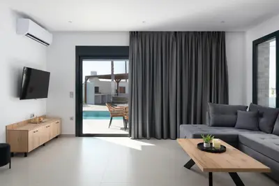 a living room with a couch and a table at Davlakos Villa Eve in Kremasti