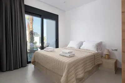 a bedroom with a large bed with towels on it at Davlakos Villa Eve in Kremasti