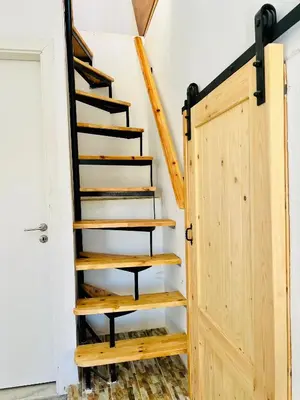 a staircase in a house with a wooden door at Symi Roots House in Symi