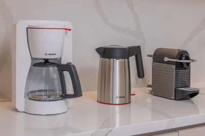 a blender and a coffee maker on a counter at Earthy Haven-Minimalist Luxury Studio & Hot Tub in Rhodes Town
