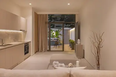 a living room with a couch and a kitchen at Earthy Haven-Minimalist Luxury Studio & Hot Tub in Rhodes Town
