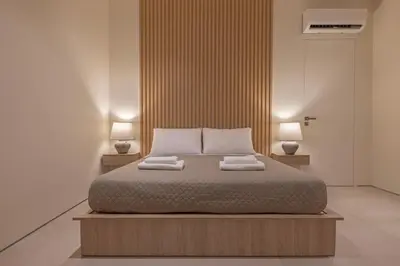 a bedroom with a bed with two towels on it at Earthy Haven-Minimalist Luxury Studio & Hot Tub in Rhodes Town