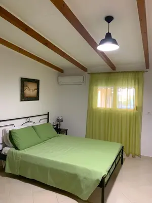a bedroom with a green bed and a window at SERENITY House in Faliraki