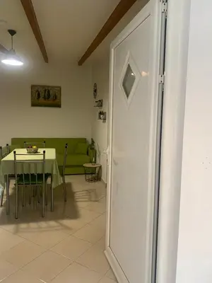 a living room with a table and a green couch at SERENITY House in Faliraki