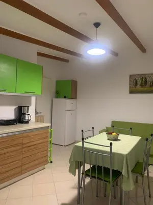 a kitchen with a table and a kitchen with green cabinets at SERENITY House in Faliraki