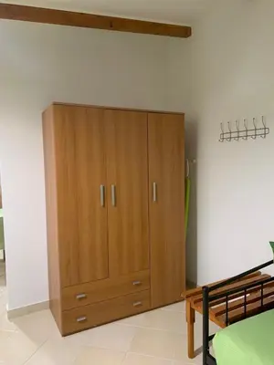 a wooden cabinet in the corner of a room at SERENITY House in Faliraki