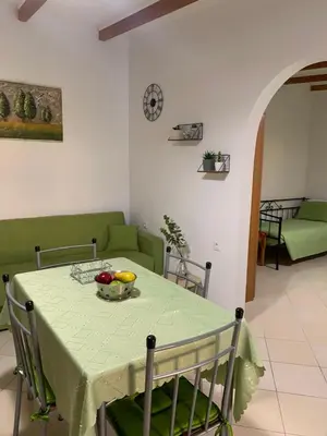 a green table with a bowl of fruit on it at SERENITY House in Faliraki