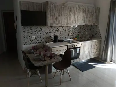 a kitchen with a table with chairs and a television at Helene Mirteni in Ialyssos
