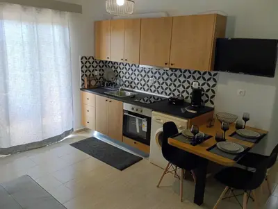 a kitchen with a table and a stove top oven at Helene Mirteni in Ialyssos
