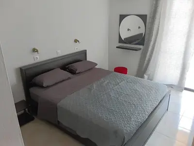 a bedroom with a bed and a mirror on the wall at Helene Mirteni in Ialyssos