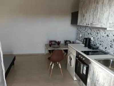 a kitchen with a table and a stove and a sink at Helene Mirteni in Ialyssos