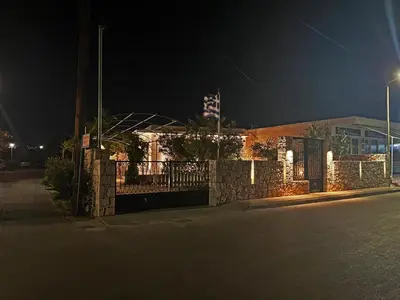 a fence in front of a building at night at ELÉNAS slow living villa in Faliraki