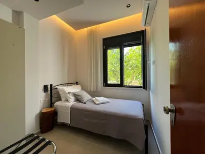 a bedroom with a bed and a window at ELÉNAS slow living villa in Faliraki