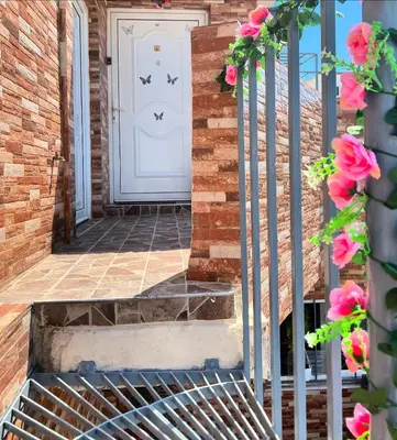 a front door of a brick house with pink roses at Cozy Rhodes Studio in Rhodes Town
