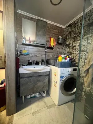a bathroom with a sink and a washing machine at Cozy Rhodes Studio in Rhodes Town