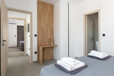 a bedroom with two beds and a mirror at Zen Club Luxury Villas in Kolimbia