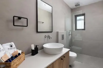 a bathroom with a sink and a toilet and a mirror at Zen Club Luxury Villas in Kolimbia