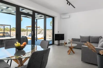 a living room with a glass table and a couch at Zen Club Luxury Villas in Kolimbia