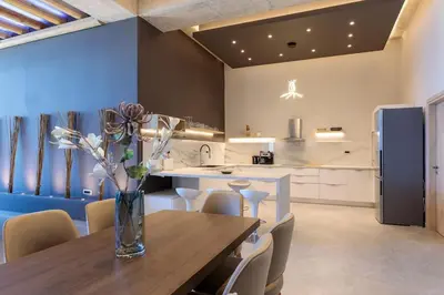 a kitchen with a wooden table with a vase of flowers at Evie's Oasis in Ixia