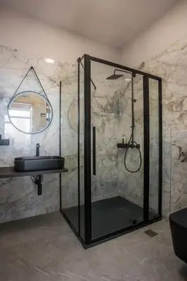 a bathroom with a glass shower and a sink at Evie's Oasis in Ixia