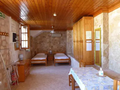 a room with two beds and a wooden ceiling at Nikitas Studio in Halki