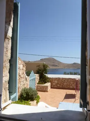 an open door to a patio with a view of the water at Nikitas Studio in Halki