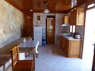 a small kitchen with a table and a refrigerator at Nikitas Studio in Halki