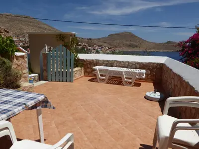 a patio with a table and chairs on a wall at Nikitas Studio in Halki