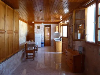 a kitchen with wooden cabinets and a table and chairs at Nikitas Studio in Halki
