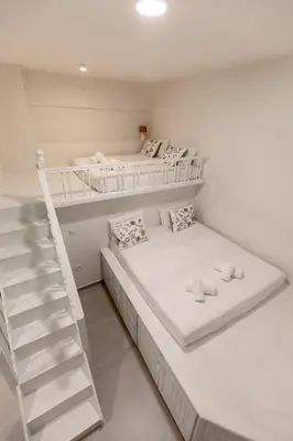 a white room with two bunk beds and a ladder at Villa Basilio in Gennadi