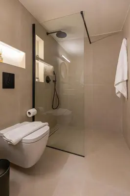 a bathroom with a toilet and a glass shower at Villa Basilio in Gennadi