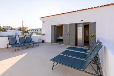 a pair of blue lounge chairs on a balcony at Villa Basilio in Gennadi